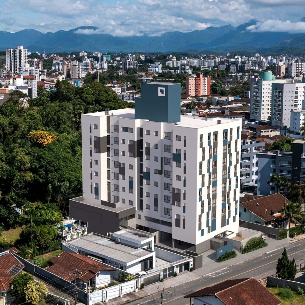 Vista aérea de bairro urbano com edifício moderno em destaque, mostrando como novos empreendimentos impulsionam a valorização de imóvel na região.
