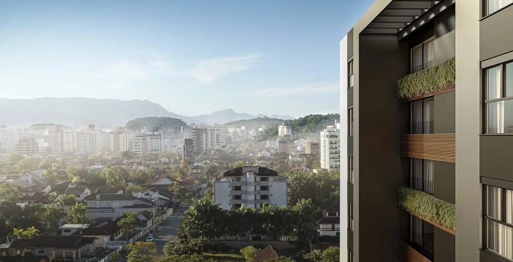 Vista panorâmica de edifícios residenciais e área verde no entorno do Bairro América em Joinville.