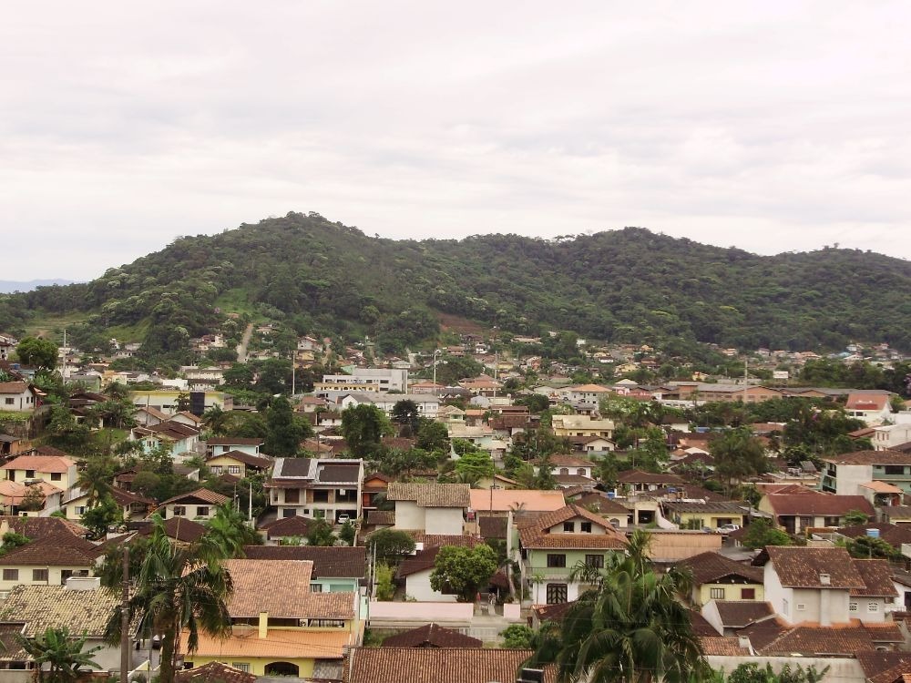 Vista aérea de bairro residencial com casas e áreas verdes, ilustrando qual o custo de vida em Joinville e o perfil das regiões urbanas da cidade.