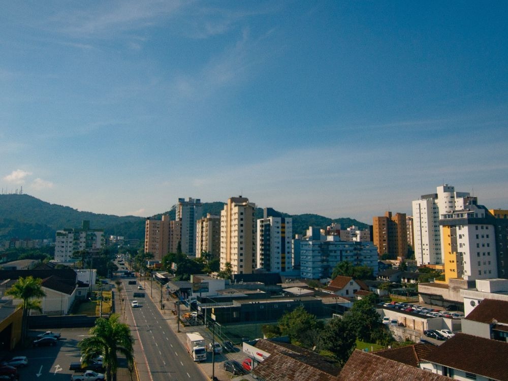 Avenida movimentada de Joinville com prédios residenciais mostrando se Joinville é segura para viver e investir