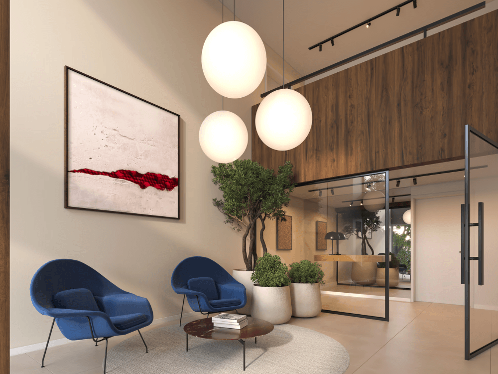 Hall de entrada elegante com poltronas, plantas e iluminação moderna em empreendimento residencial.