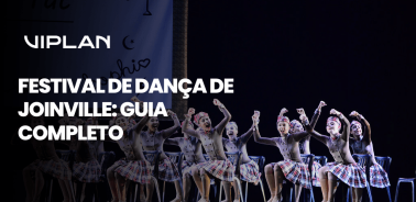 Arte de capa do guia completo sobre o Festival de Dança de Joinville com imagem de apresentação infantil ao fundo.