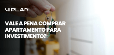Pessoa segurando chave de imóvel com pingente em formato de casa, simbolizando o momento de conquista e reflexão sobre vale a pena comprar apartamento para investimento.